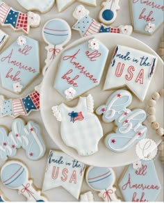 decorated cookies are displayed on a plate in the shape of flags, stars and pennants