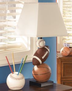 a lamp that is sitting on top of a table next to a baseball and ball