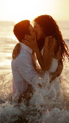 two people in the water kissing each other