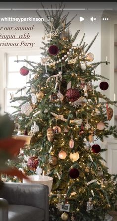 a christmas tree with ornaments on it in a living room