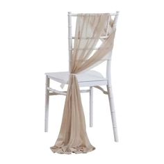 a white chair with a beige scarf draped over it's back and seat cover