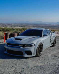 a white car parked on top of a gravel road