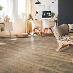 a living room filled with furniture and wooden flooring next to a window on top of a hard wood floor