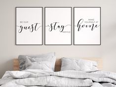 two posters with the words be our guest and stay home on them above a bed