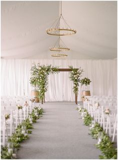 the aisle is lined with white chairs and greenery for an outdoor wedding ceremony at their venue