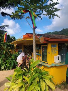 a man standing in front of a kiosk with a rainbow flag on it