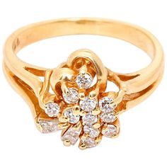 a yellow gold ring with diamonds on the bottom and an open flower in the middle