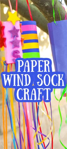 paper wind sock craft hanging from a tree with text overlay that says paper wind sock craft