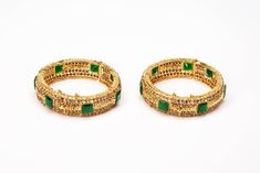 Timeless is the word for this Gold-tone plated set of cuff bangles that features a sophisticated setting of square crystals in a vibrant emerald color. Framed in sparkling clear zircon lines, it heavenly combines with a vast variety of attire to bring on that bling. Pair it with a watch or add bangles to form a bridal set, choice is all yours. Gold Jeweled Bangle For Anniversary, Gold Jeweled Bangle For Wedding, Gold Bangle With Jewels For Weddings, Rectangular Gold Jewelry For Ceremonial Occasions, Rectangular Gold Ceremonial Jewelry, Gold Wedding Bangle With Jewels, Ceremonial Gold Rectangular Jewelry, Traditional Gold Jeweled Bangle, Traditional Jeweled Bangle For Formal Occasions