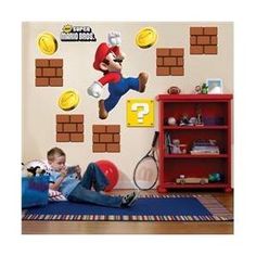 a kid laying on the floor in front of a wall with mario bros stickers