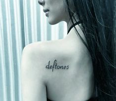 the back of a woman's shoulder that says deftones on her left side