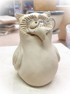 a clay owl with glasses on it's head