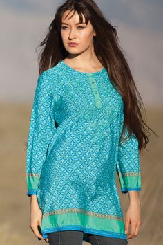 Our Deena Tunic showcases the beautiful hand embroidery done by women artisans in Northern India on a soft, printed poly-silk blend. The classic sari print of this hand embroidered tunic top is enhanced by the traditional Indian embroidery motifs on the front and back. One of our most popular styles and designed for a comfortable, elegant fit, these hand embroidered tunics come in a range beautiful jewel tones. Hand Embroidered Tunics, Indian Tunic, Fair Trade Clothing, Embroidered Tunic Top, Silk Tunic, Embroidery Motifs, Indian Embroidery, Embroidered Tunic, Floral Tunic