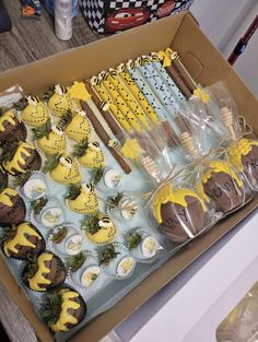 a box filled with lots of yellow and brown cupcakes on top of a table