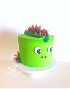 there is a green cake decorated like a plant with googly eyes on the top