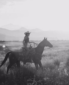 a man riding on the back of a horse across a field