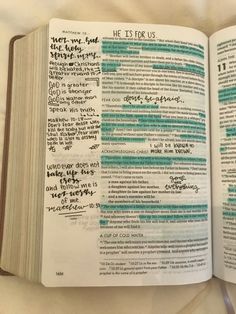 an open bible with handwritten words on the pages and in blue ink that reads he is for us