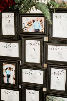 the table numbers were placed in black frames with red roses on them and greenery