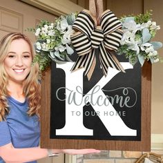 a woman holding up a sign that says welcome to our home