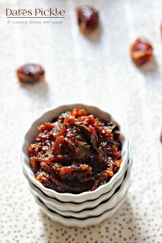 dates pickle in a small bowl on a white tablecloth with scattered raisins