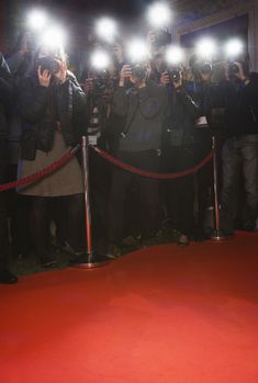 a group of people standing on top of a red carpet