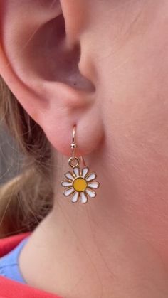 This enchanting set of dainty daisy earrings features a delicate design that captures the simple beauty of nature. Each earring showcases a charming daisy, complete with pristine white petals that encircle a bright yellow center, evoking the cheerful essence of a sunlit meadow. The petals are meticulously crafted to reflect the purity and grace of the daisy, while the vibrant yellow center adds a pop of color, drawing the eye and brightening the overall appearance of the earrings. The daisies ar Mothers Day Earrings, Earrings For Mom, Gentle Movement, Gold Hooks, White Petals, Color Drawing, Gift For Mothers Day, Daisy Earrings, Earrings Flower