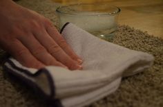 a person is cleaning the floor with a towel and cloth next to a glass of water