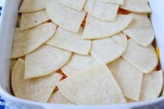 a casserole dish filled with tortilla chips on a blue and white checkered cloth