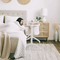 a woman is laying in bed with her head on the pillow while talking on the phone