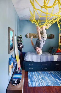 a young boy is upside down on his bed