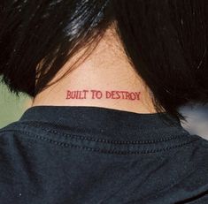 the back of a woman's neck that says built to destroy in red ink