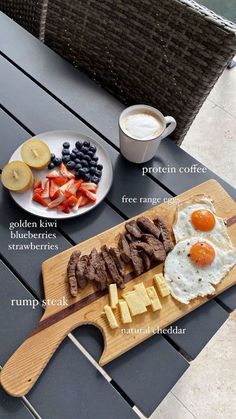 a wooden cutting board topped with meat and eggs