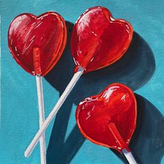 two heart shaped lollipops on a blue background