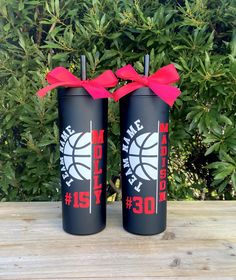 two black tumblers with red ribbon tied around them