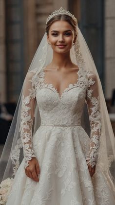 a woman wearing a wedding dress with long sleeves and a veil on her head is posing for the camera