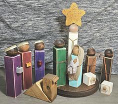 a nativity scene made out of wood and painted with different colors, shapes and sizes