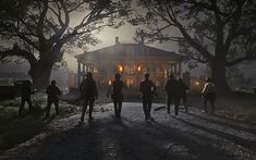 a group of people standing in front of a house at night with the lights on