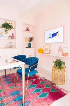 a living room filled with furniture and a rug on top of a wooden floor next to a white table