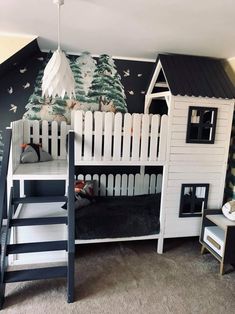 there is a bunk bed with a white fence and trees on the wall next to it