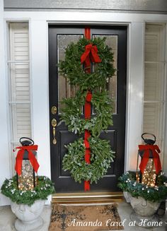 the front door is decorated with wreaths and lights