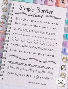 a notebook with some stickers on top of it next to an assortment of pens and markers