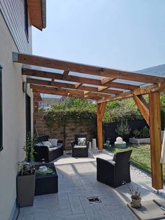 an outdoor living area with patio furniture and wooden pergolated roof over the back yard