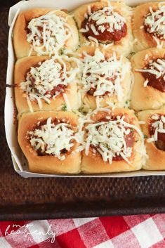 a square casserole dish filled with meatballs and cheese on a red checkered tablecloth