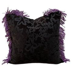 a black and purple pillow with fringes on it