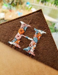 a close up of a piece of fabric with flowers on it and the letter h