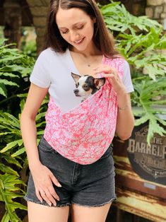 a woman in shorts and a t - shirt with a dog on it's chest