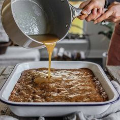 a person pouring sauce into a casserole dish