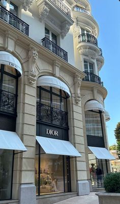 a tall building with many windows and white awnings