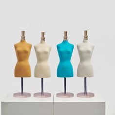 three mannequins with different colored tops on display in front of a white background