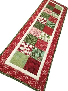 a red and green table runner with flowers on it